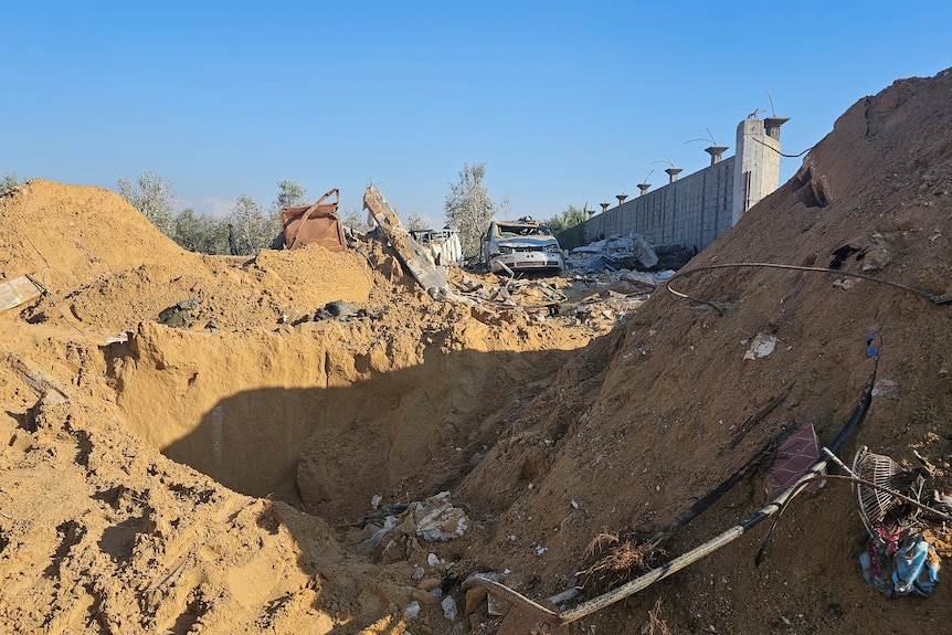 Piles of dirt and debris surround a big hole in the ground.