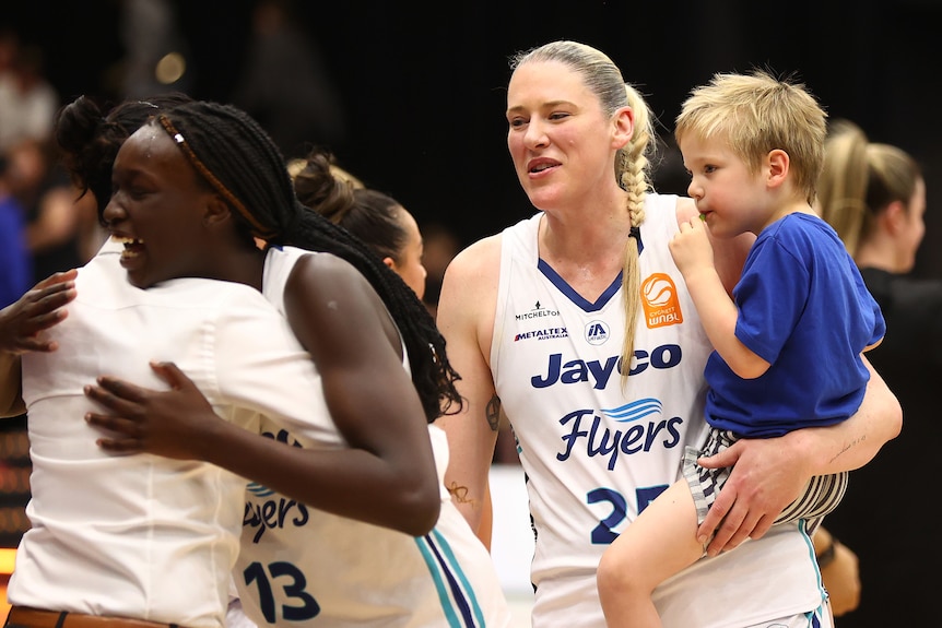 Lauren Jackson holds a boy in one arm