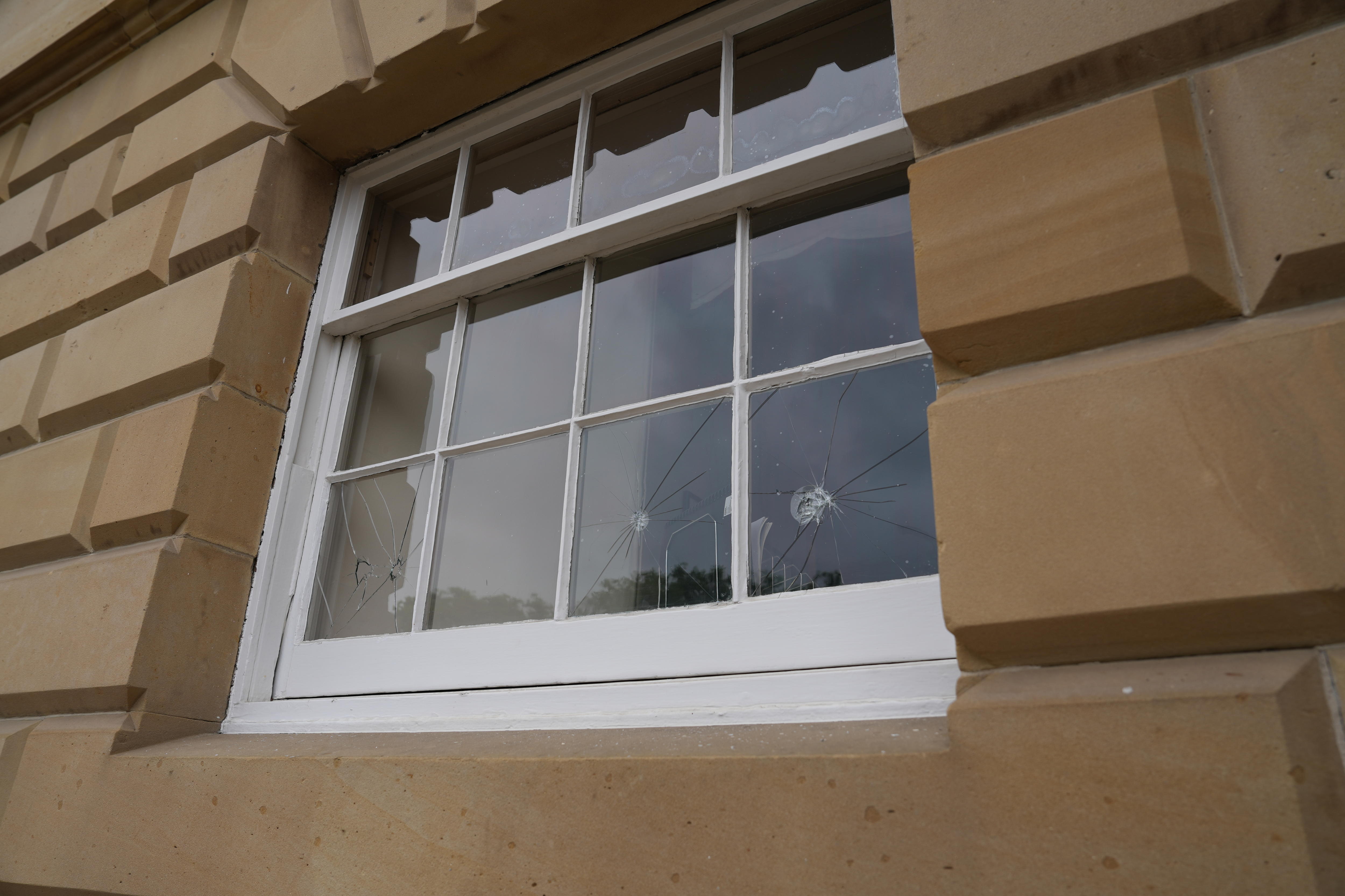 smashed glass windows in a sandstone building