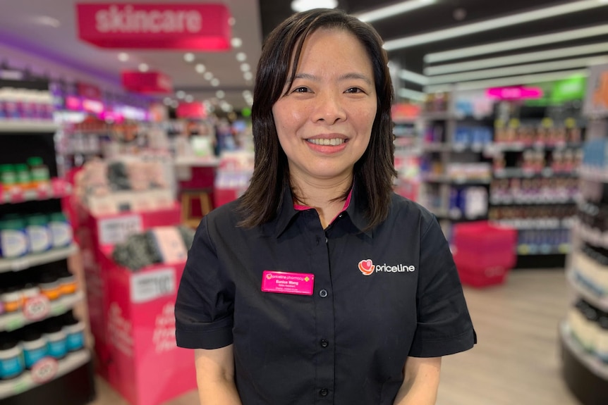 Eunice Wang works at Priceline. She is standing in the shop in her uniform.