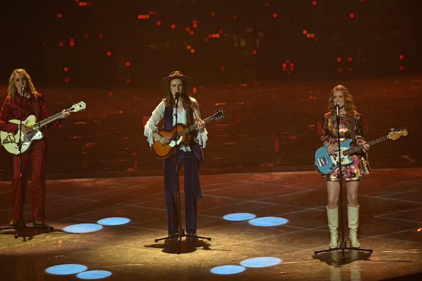三名妇女在她们的吉他和手上拿着用丝带制成的小乌克兰国旗。