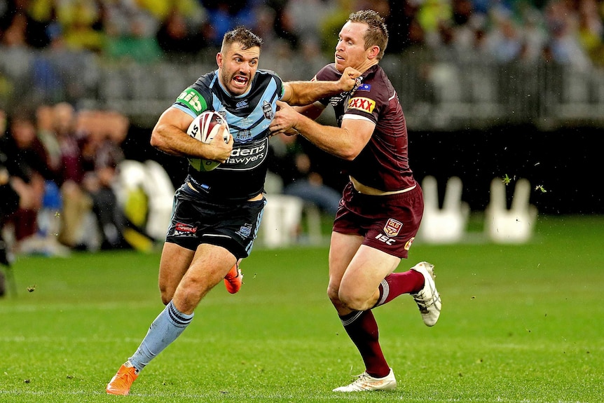 James Tedesco fends off Michael Morgan with the ball tucked under one arm