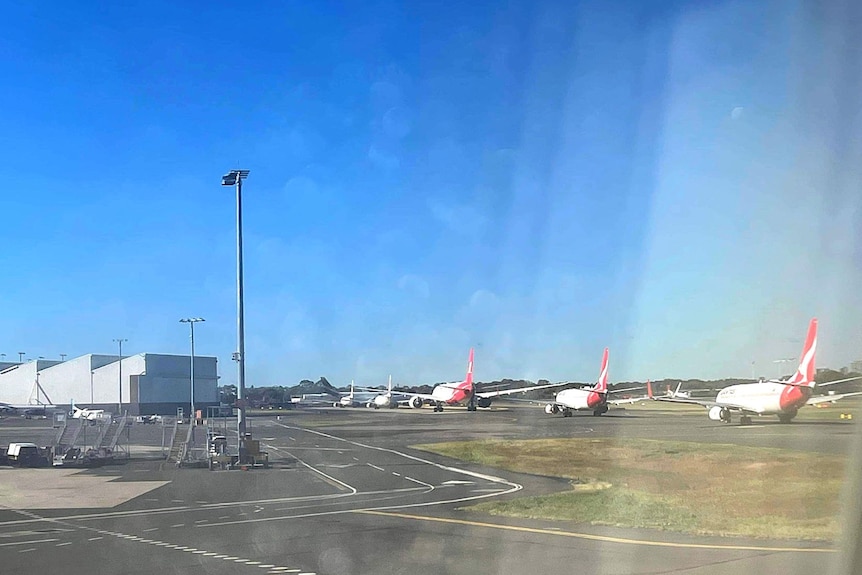 Seven plans filed at Sydney airport amid travel chaos, shot through plane window