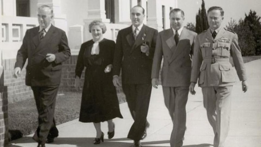Robert Menzies, Enid Lyons and others walk outside Parliament House