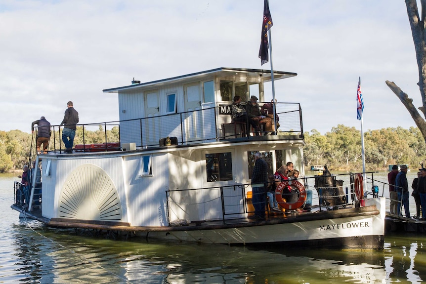 People sit on board the Paddle Boat Mayflower on the Murray River at Wentworth.