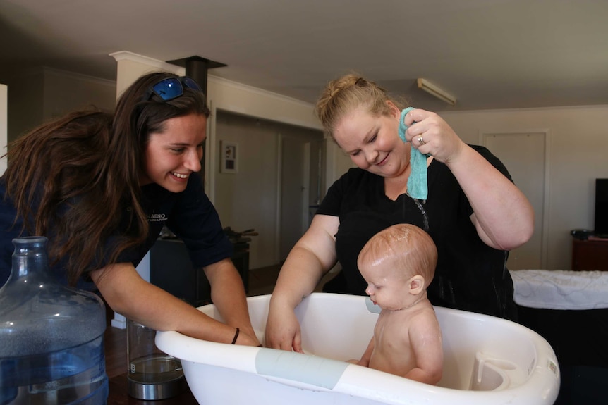 A baby has a bathe in a tub