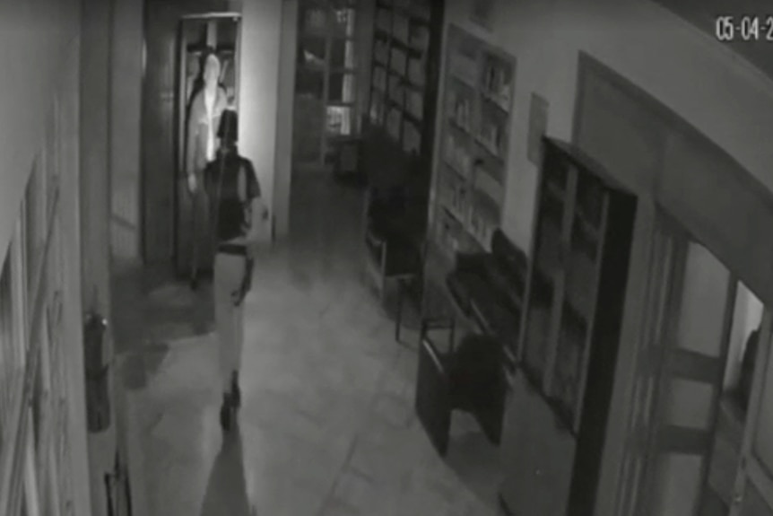 Black and white CCTV footage of a soldier in a room 