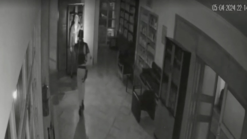 Black and white CCTV footage of a soldier in a room 