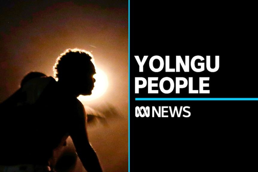 Yolngu People: Man crouches silhoueted by the sun