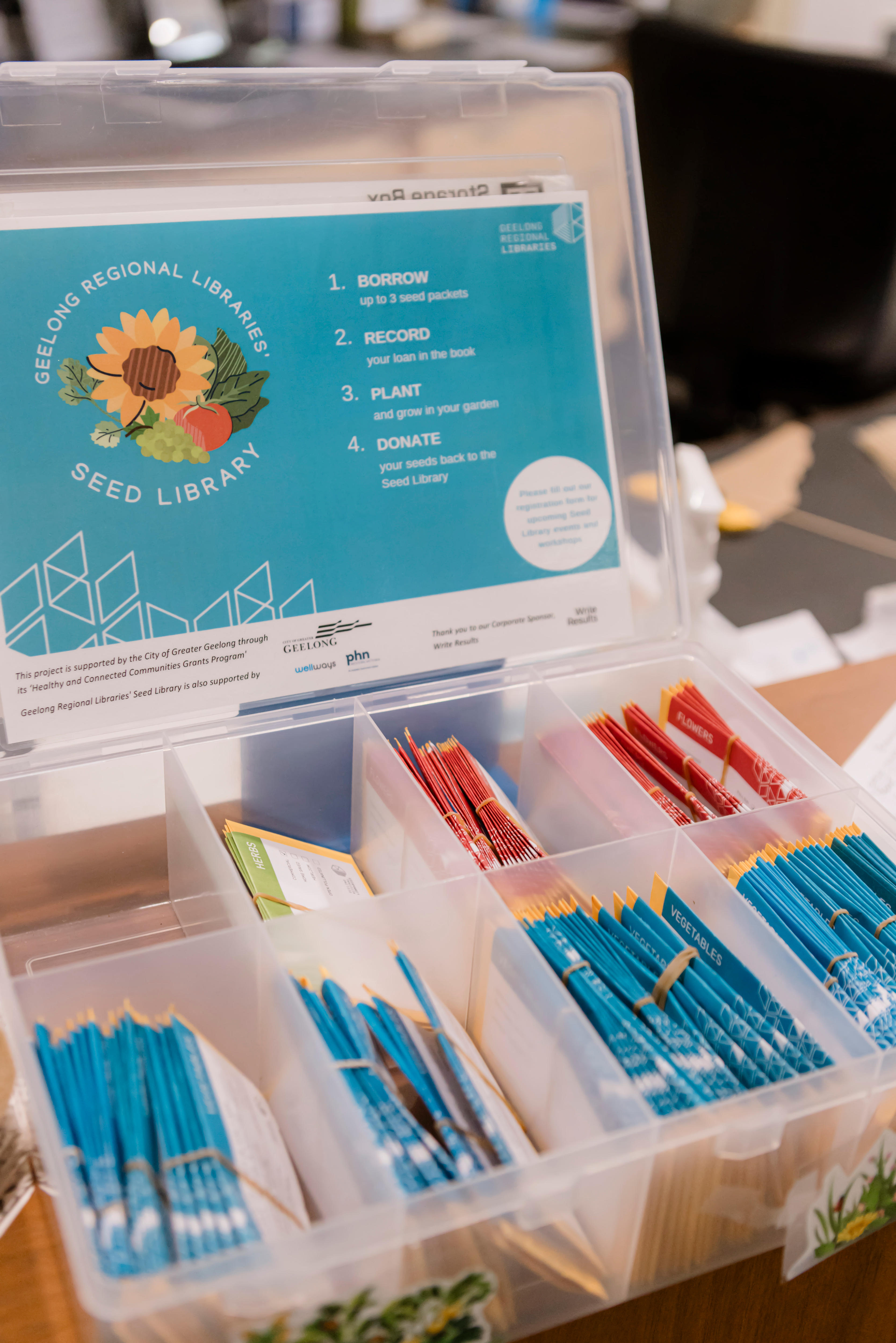 A plastic box with seed packages on a shelf.