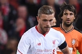 Spirited affair ... The Roar's Dimitrios Petratos (L) competes for the ball with Liverpool's Jordan Henderson