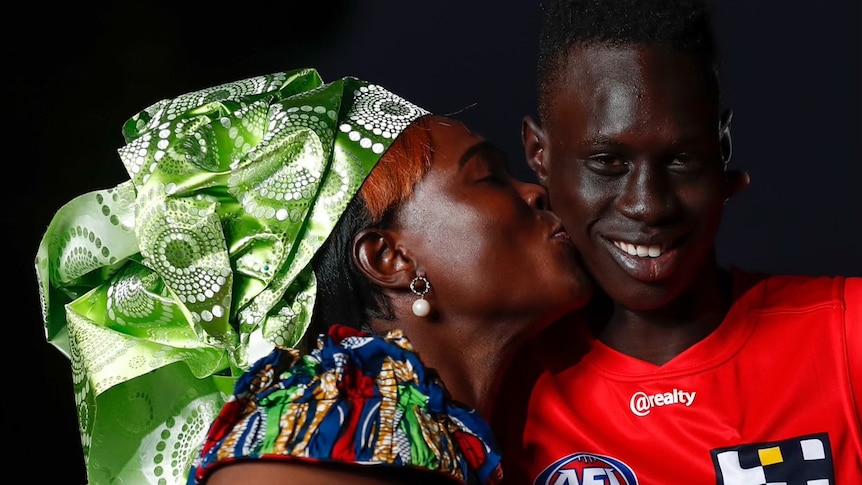 Mac Andrews receives a kiss on the cheek from his mum.