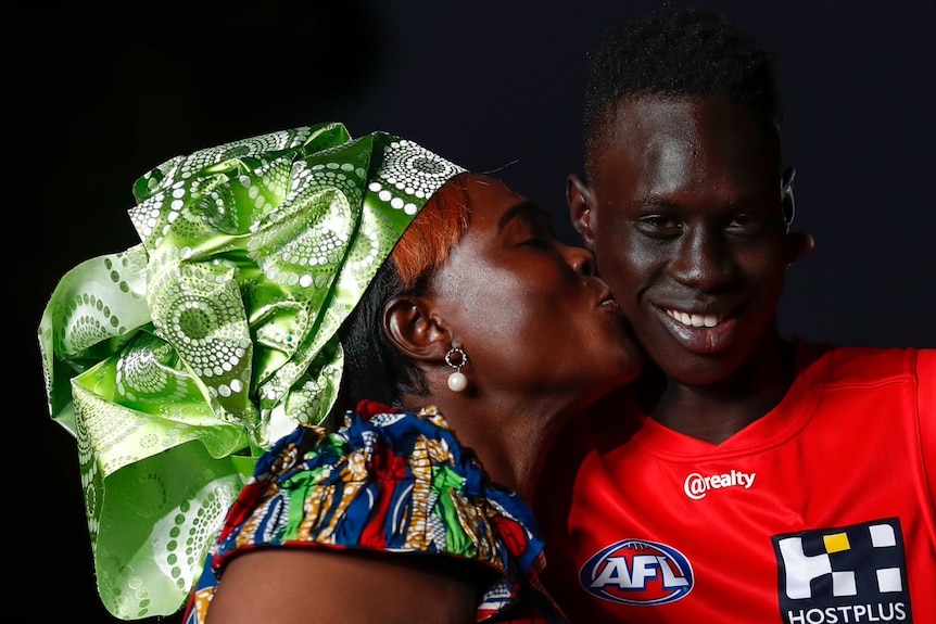 Mac Andrews receives a kiss on the cheek from his mum.