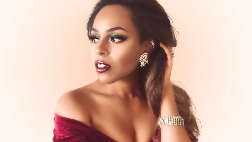 A portrait of Lauren Henderson in a dark red dress and diamond earrings; she's looking to her right