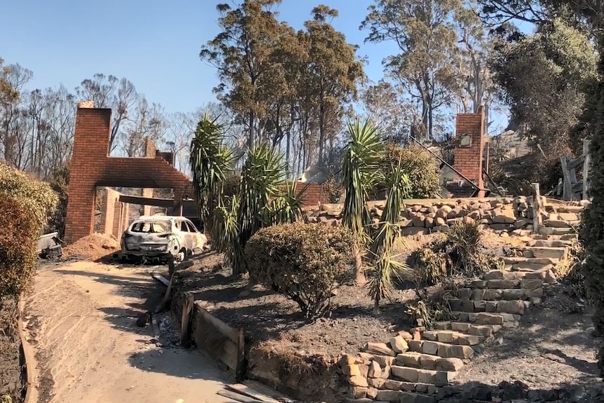 Burnt out brick house and car.