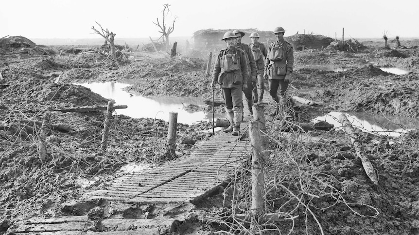 Four unidentified soldiers walking along a duckboard track near Zonnebeke, in the Ypres sector.