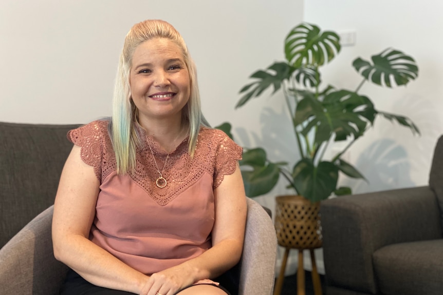 woman smiles sitting on chair