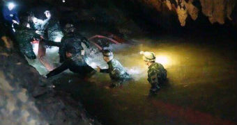 Men walk through waist deep water