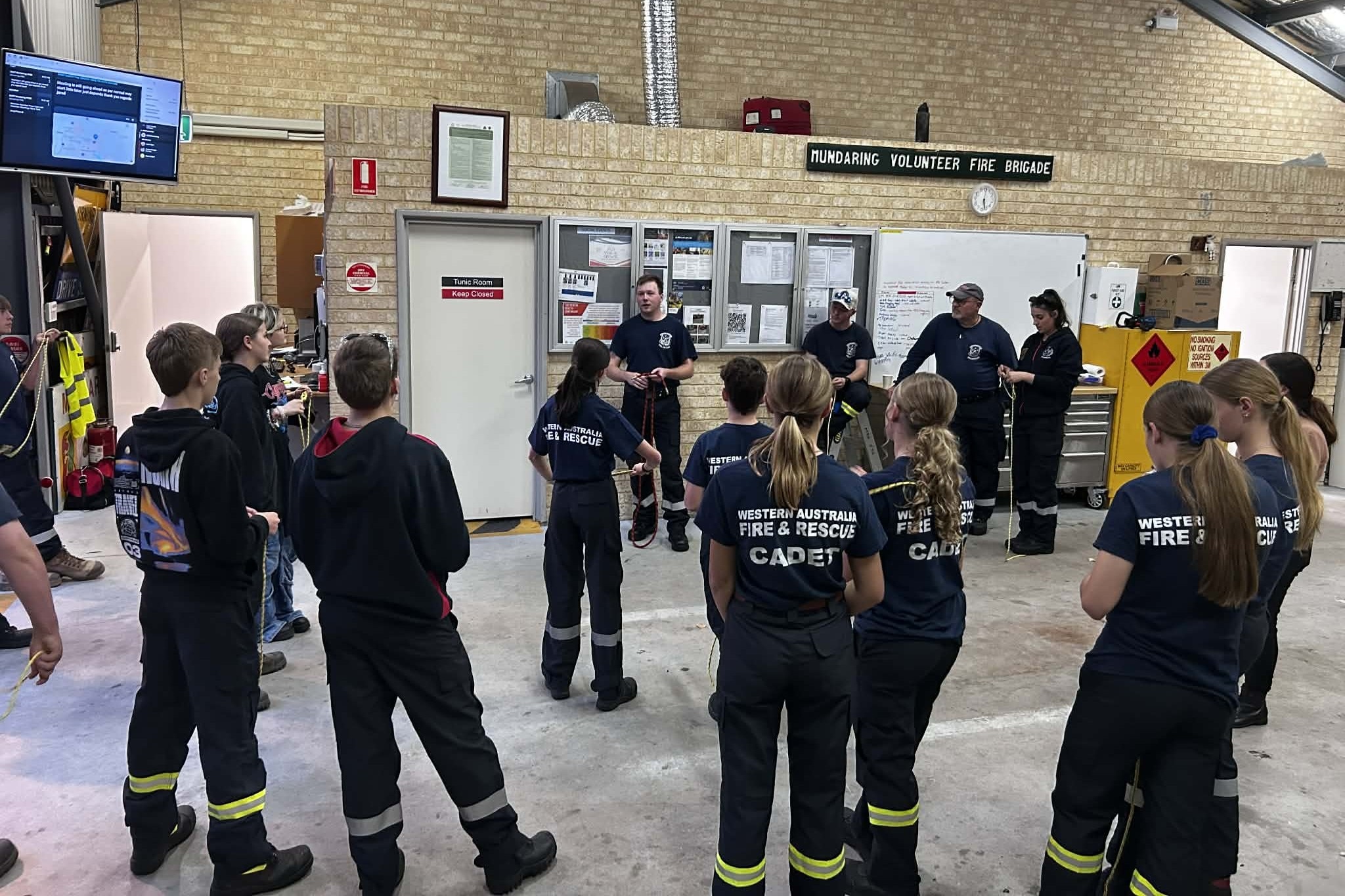 Un grupo de personas están paradas con camisetas y pantalones de bombero. 