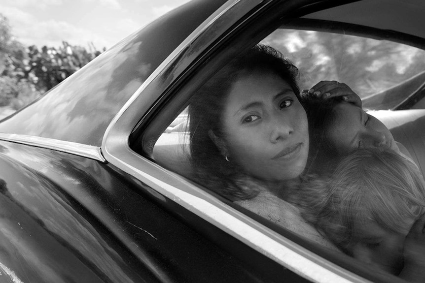 Yalitza Aparicio looks out a window from the backseat of a car