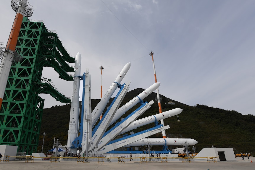 Five rockets stand at different angles on a launch pad.