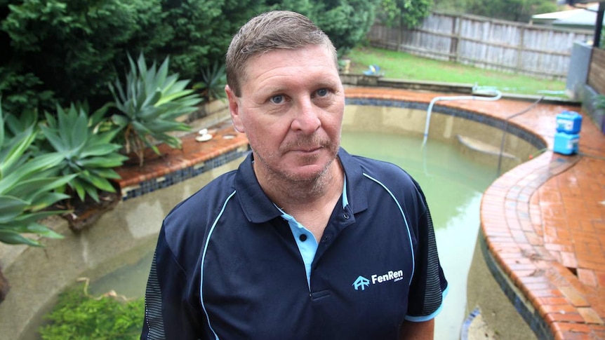 A man in front of a pool