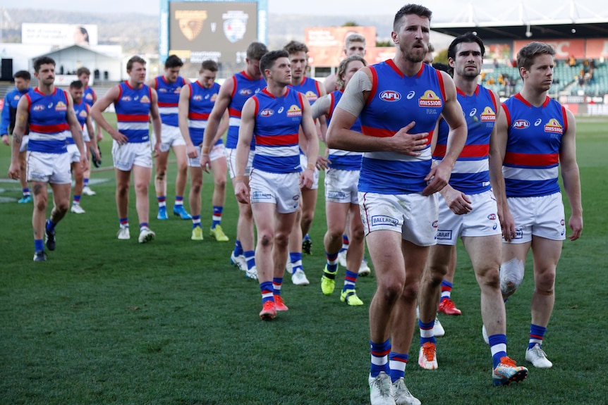 A group of dejected Western Bulldogs players leave the ground in Launceston after a loss to the Hawks. 