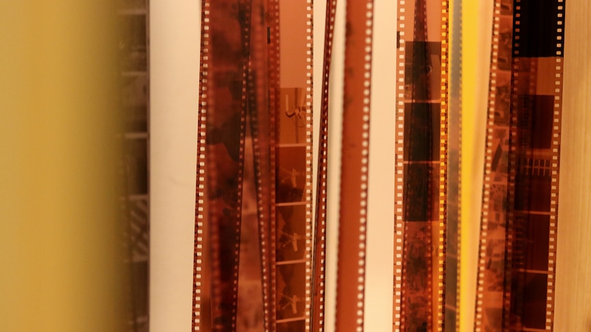 Film negatives hang inside Kelsey Hopkins' Wollongong film lab.