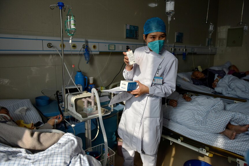 一名护士向医院的病人展示药物。
