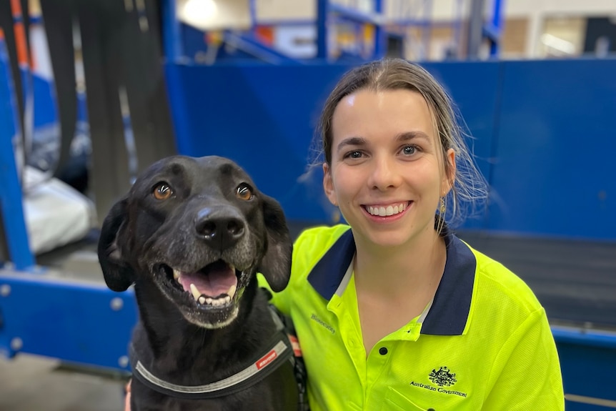 black dog with woman in high vis smiling