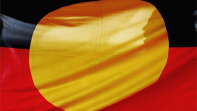 Australian Aboriginal flag with a woman silhouetted behind