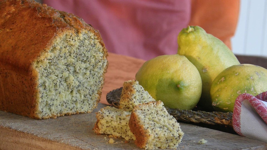 A baked cake sitting on a chopping board.