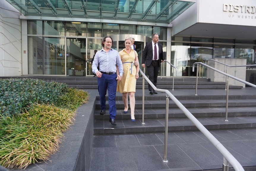 Jacob and his wife walk down stairs from court