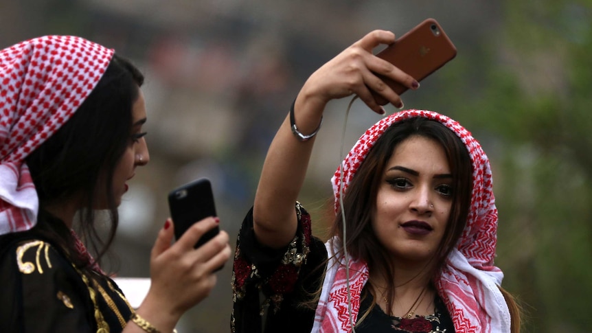 Iraqi Kurdish women take pictures of Zoroastrian celebrations.