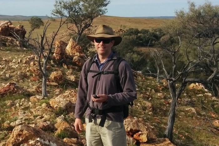 A man stands in a rocky desert