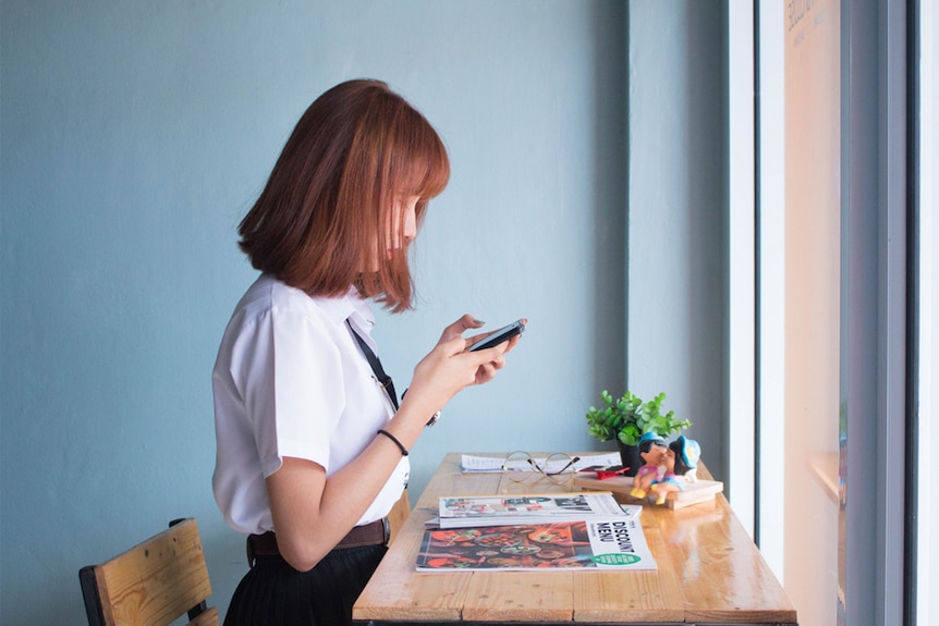 A young woman uses her smartphone.