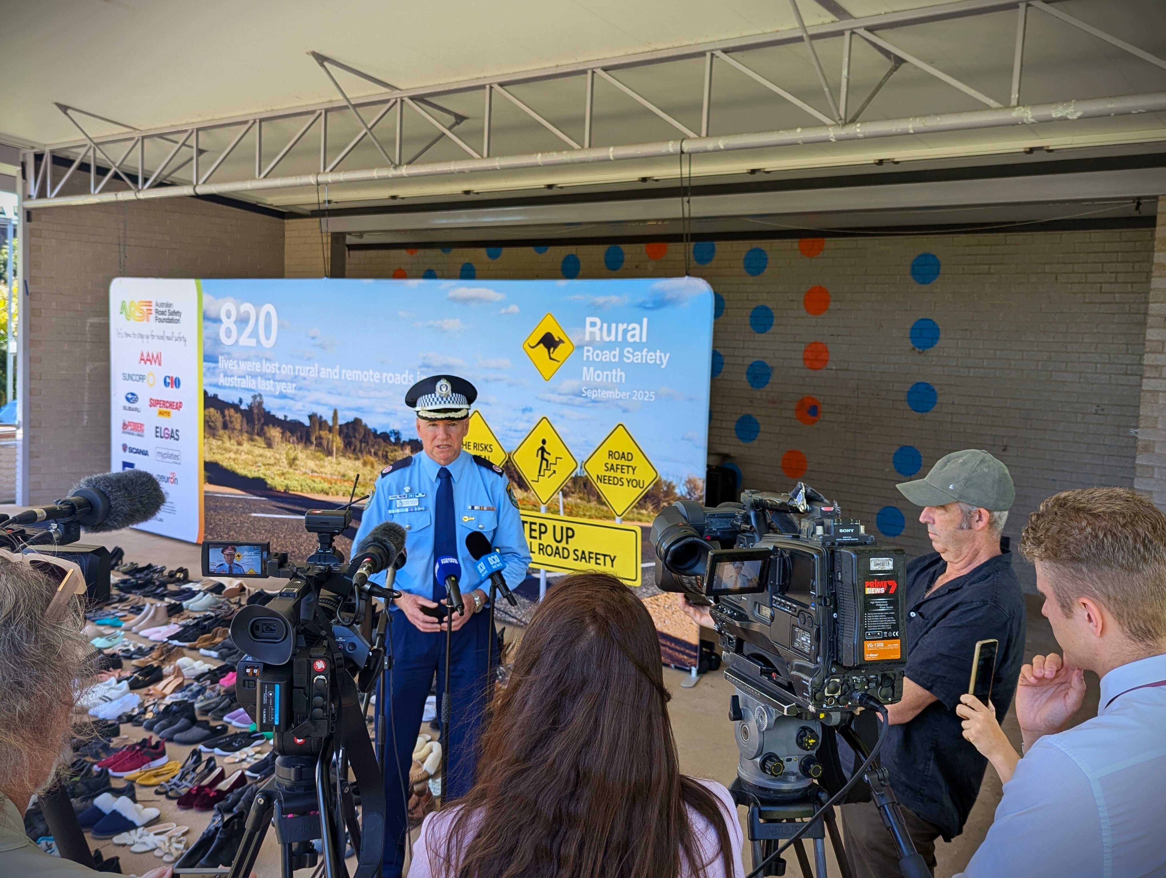 A police officer talks in front of microphones and TV cameras.