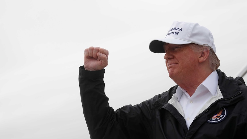 US President Donald Trump pumps his fist on a visit to the border