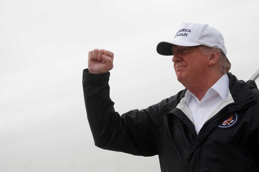US President Donald Trump pumps his fist on a visit to the border