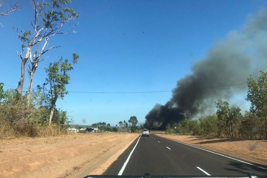 A plume of smoke seen from a 4WD in rural Darwin.