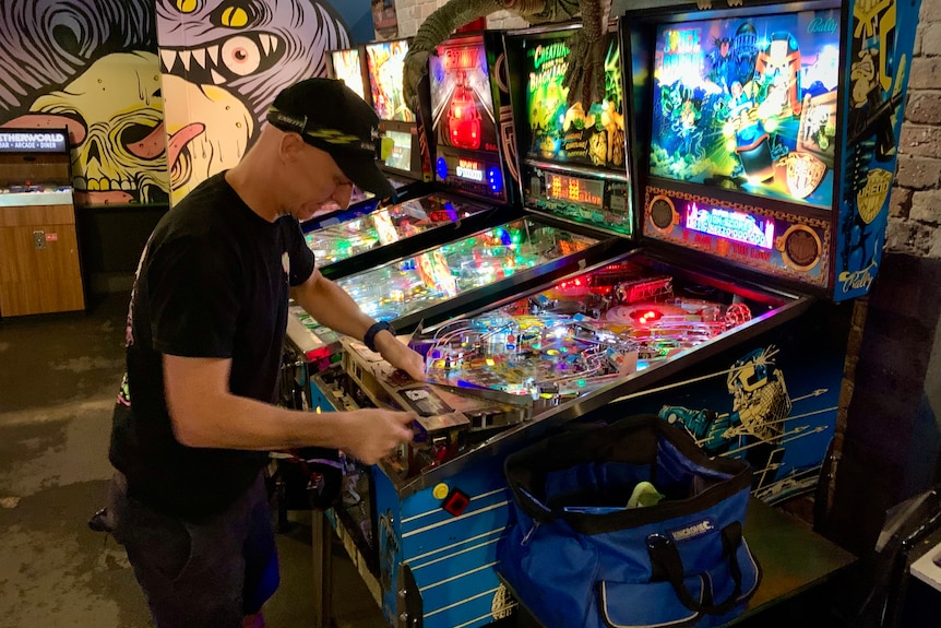 James Angliss works on a pinball machine in his arcade Netherworld in Brisbane.