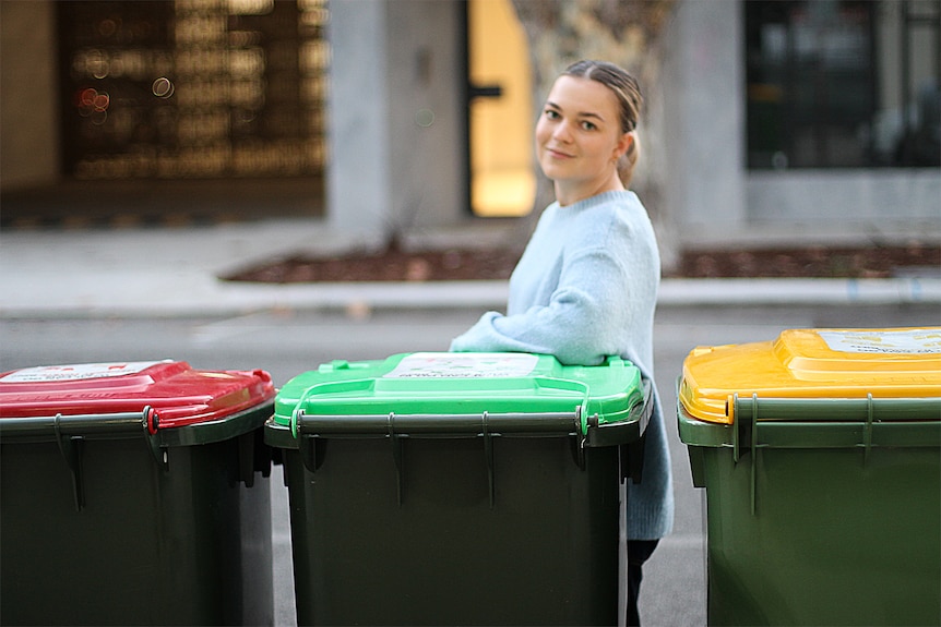 woman standing with red, green and yellow bins