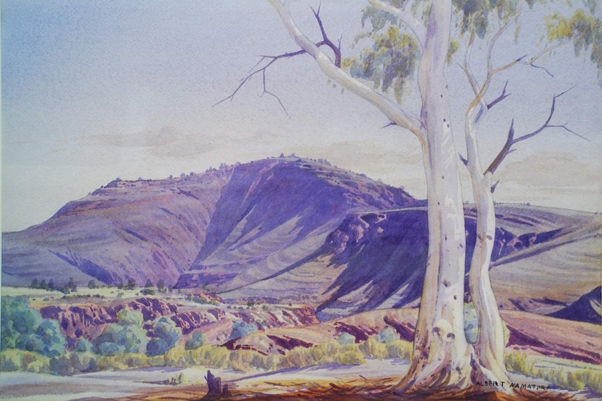 A watercolour painting of a mountain and gum tree in Central Australia.