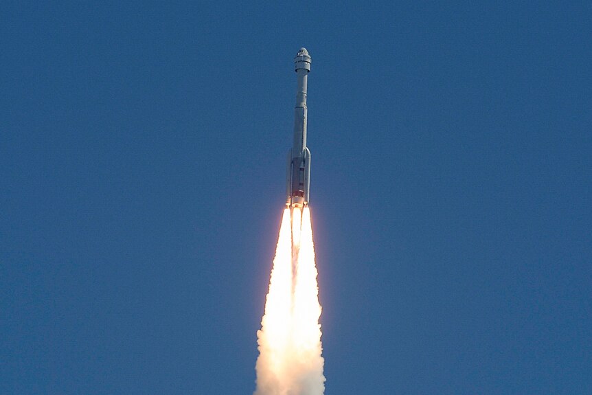 放大图像显示，一枚火箭飞向蓝天，发动机冒出火焰和烟雾