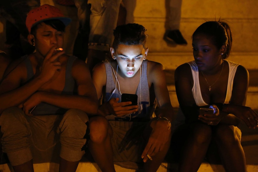 Cuban youths use a password-protected Wi-Fi network coming from a five-star hotel to surf the internet