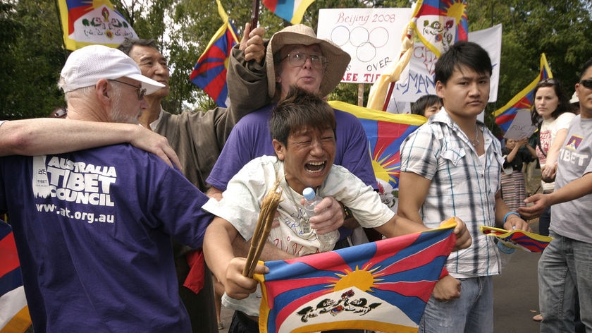 Volunteers restrain a Tibetan demonstrator