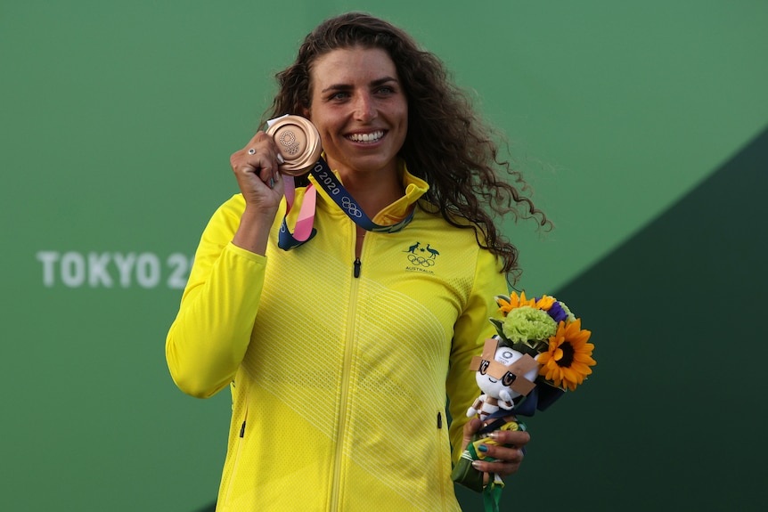 An Australian female kayaker shows off her bronze medal at the Tokyo Olympics.