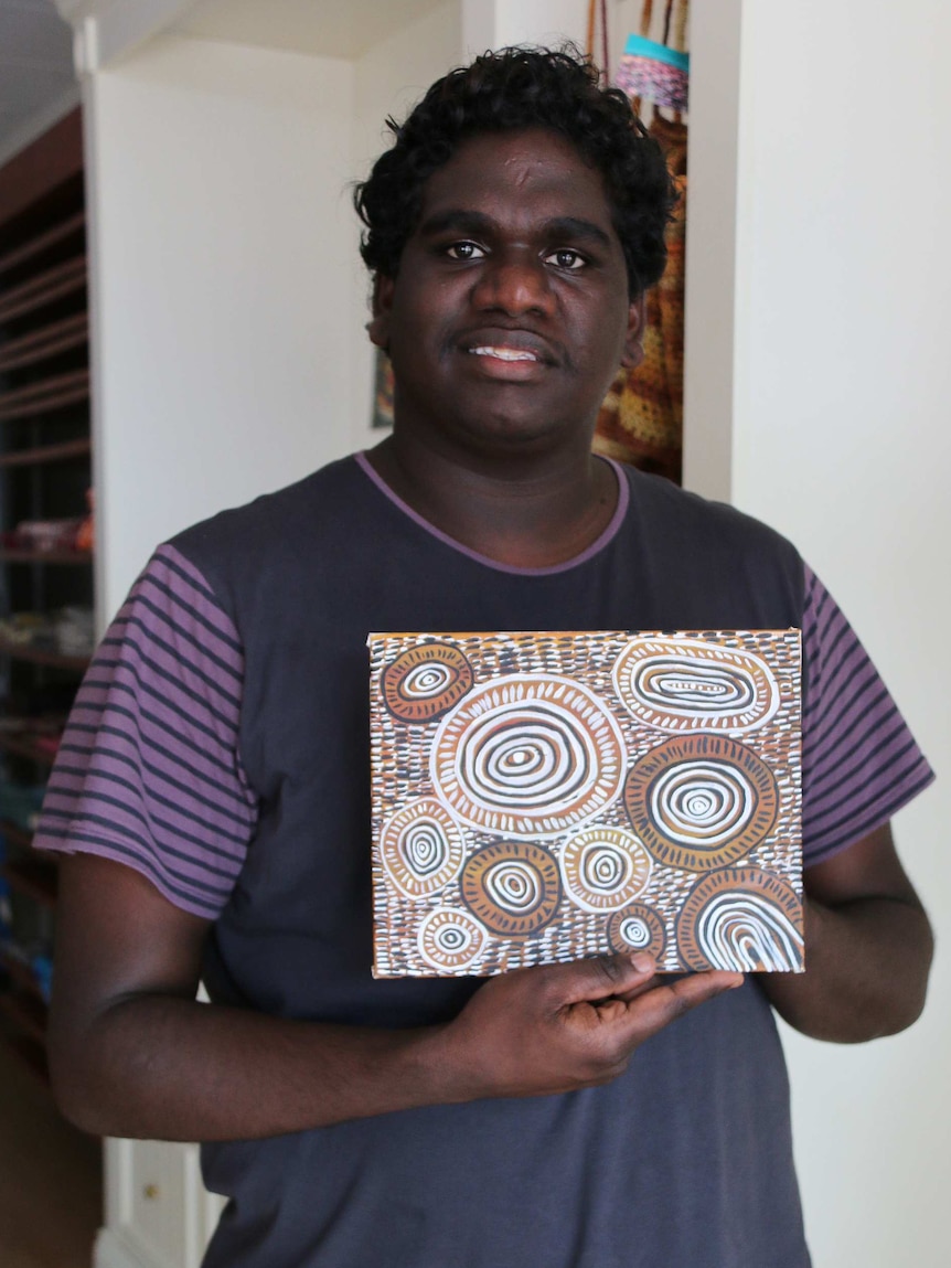 Nauiyu resident Troy Mardigan with an artwork from the community.