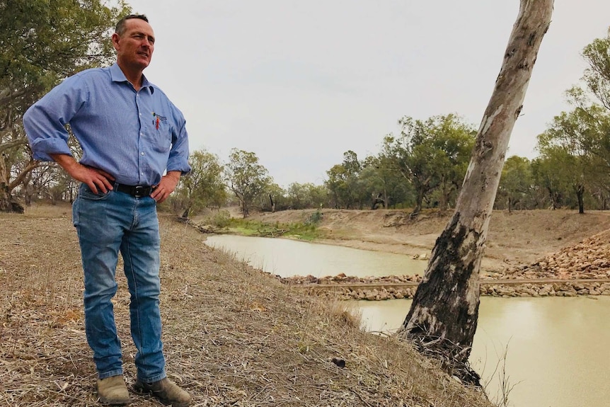 Greg Rummery standing on a river bank.