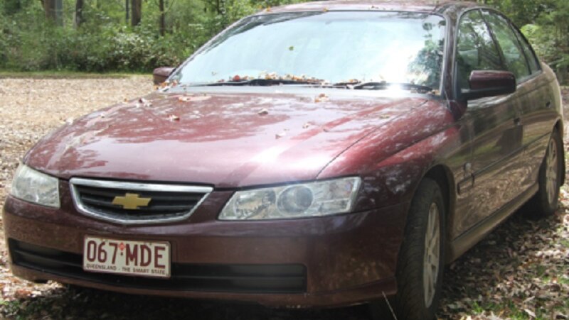 A 2003 maroon Holden Commodore sedan with Queensland registration 067-MDE.